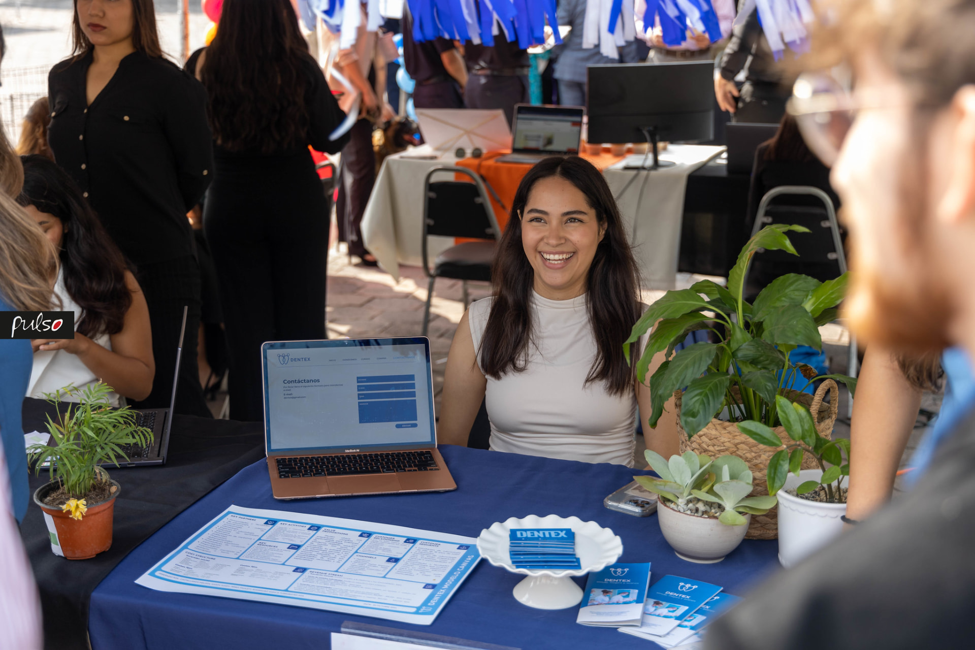 Emprendedora mostrando su proyecto con su modelo Canvas en la iExpo