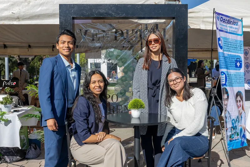 Equipo de estudiantes emprendedores junto a su stand