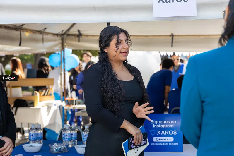 Estudiante presentando su marca a visitantes